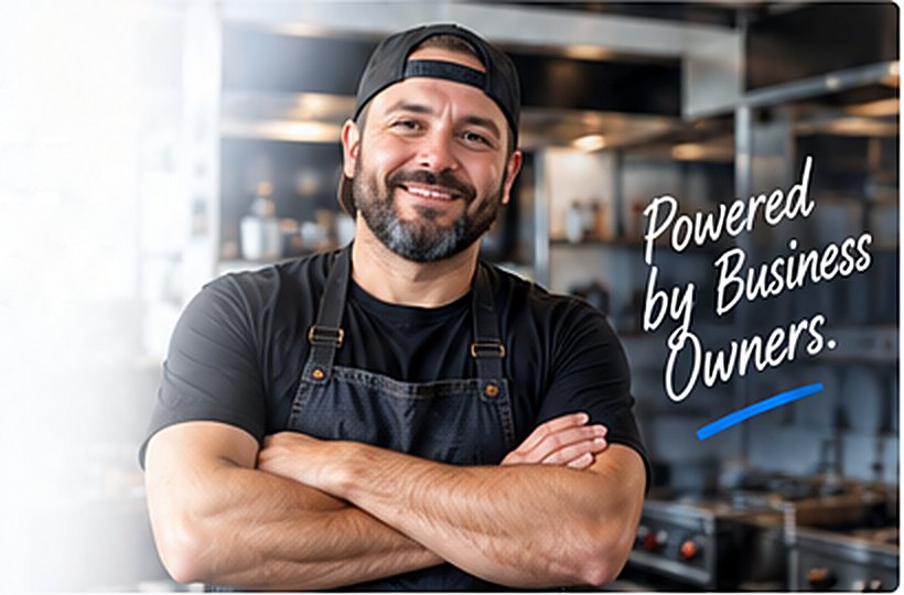 Smiling restaurant owner with arms crossed in his kitchen — Powered by Business Owners.
